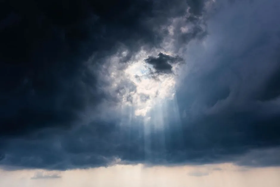 Sunlight breaking through dark storm clouds — God's faithfulness visible on the other side of the hardest season