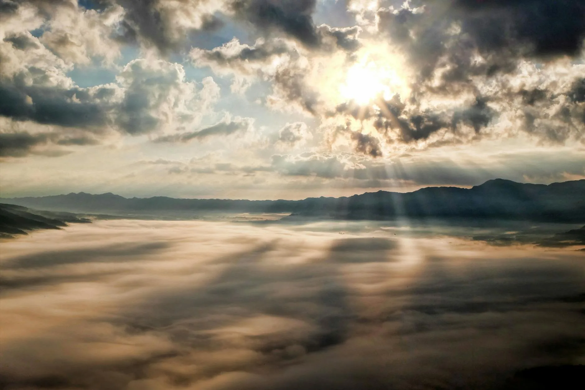 Sunrise breaking through clouds over mountains, peace that holds even when everything outside is uncertain